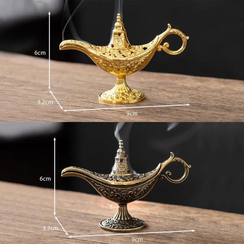 A golden antique metal incense burner with a spout and handle sits on a wooden surface.