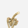 A beige fabric bow bag with a gold chain strap extension and small fruit embellishments.