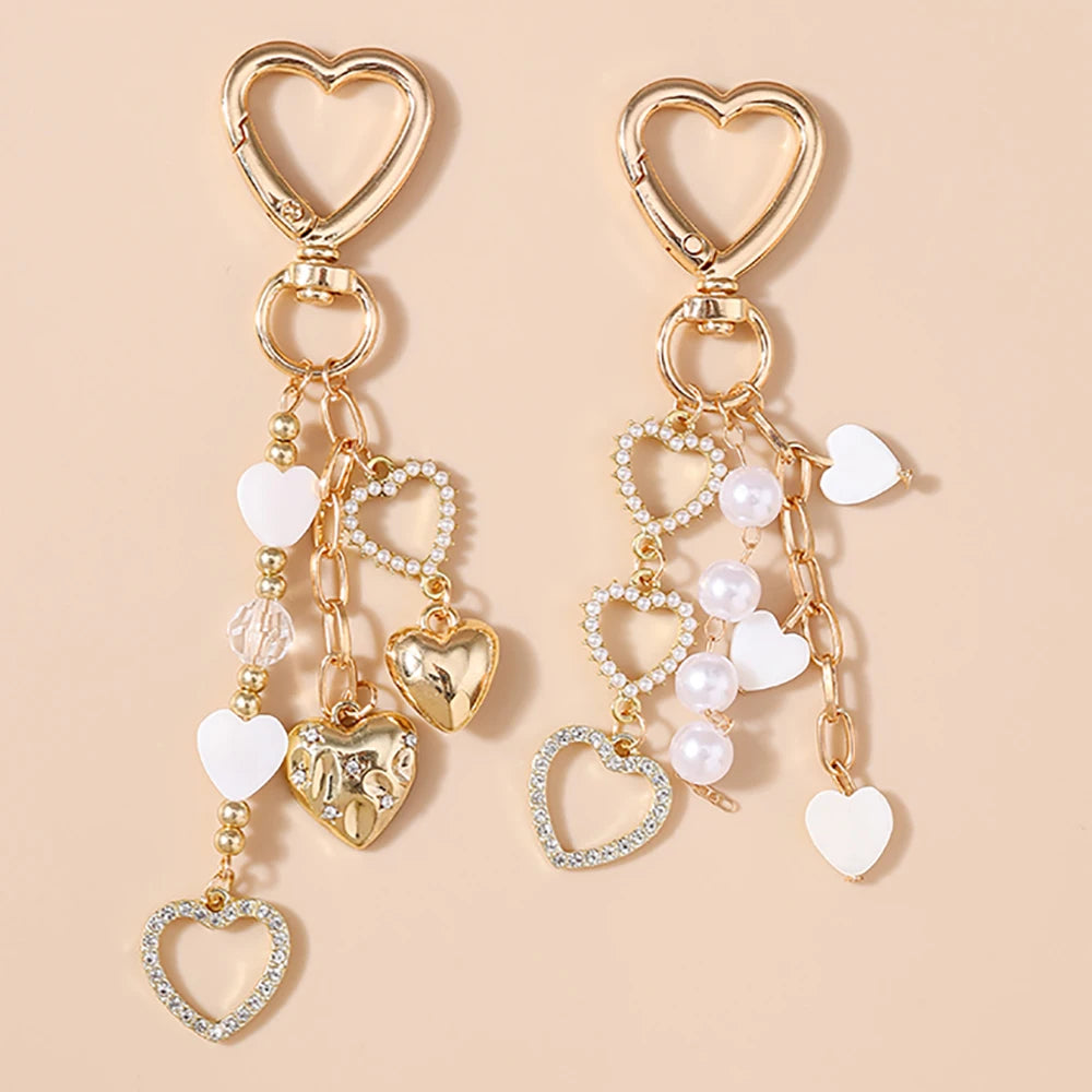 Gold-toned pearl bow heart keychain with a chain and heart charms