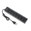 A black 7-port USB splitter hub with individual on/off switches and a cable.