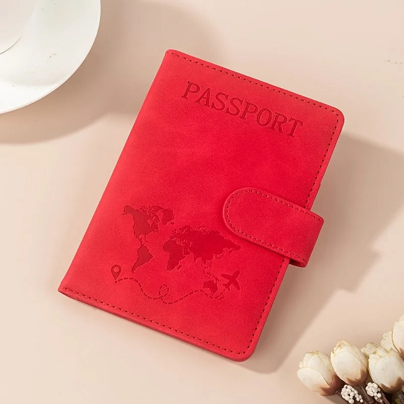 A red passport wallet with the word PASSPORT embossed on the cover resting on a light surface.