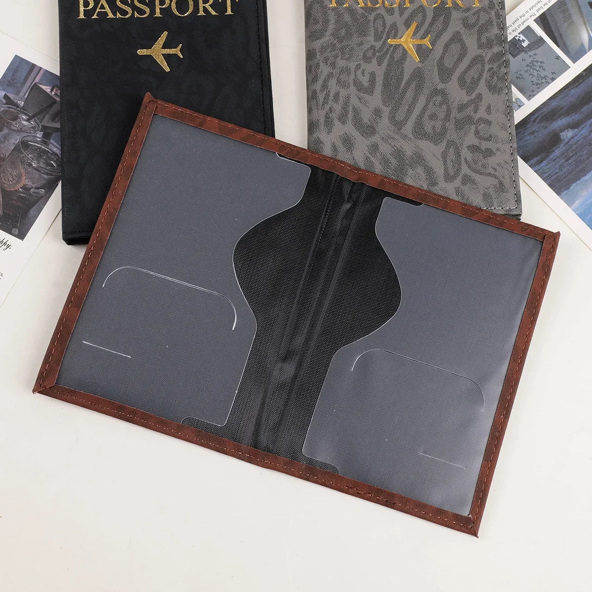 A passport holder featuring a dark gray leather cover with a leopard print design and a clear plastic insert.