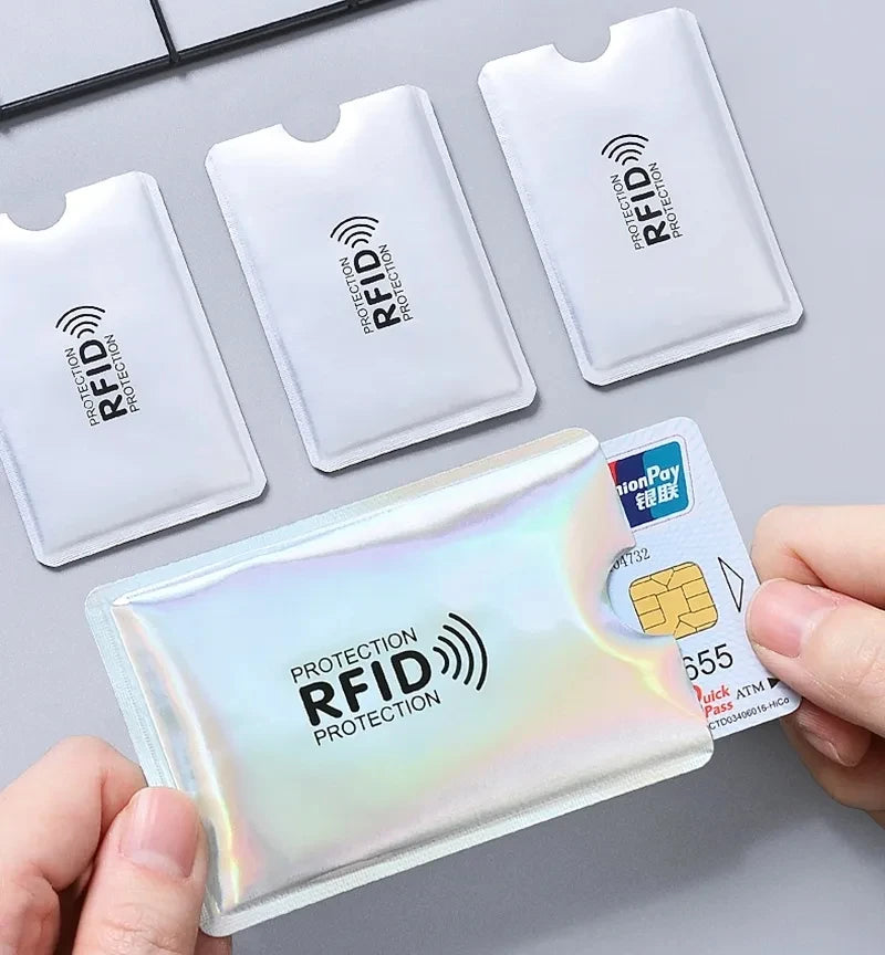 Eine Hand hält eine durchsichtige, irisierende RFID-Schutz-Geldbörsenhülle und eine Kreditkarte.