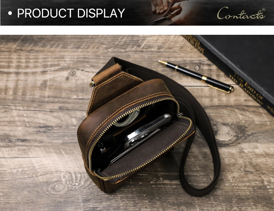 A brown genuine leather men's crossbody bag with a zippered compartment and a leather strap resting on a wooden surface.