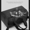 A black waterproof travel duffle bag is shown with its interior lining visible, positioned against a light gray background.