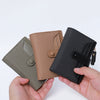 A hand holds a premium PU leather bi-fold wallet in shades of olive green, beige, and black.