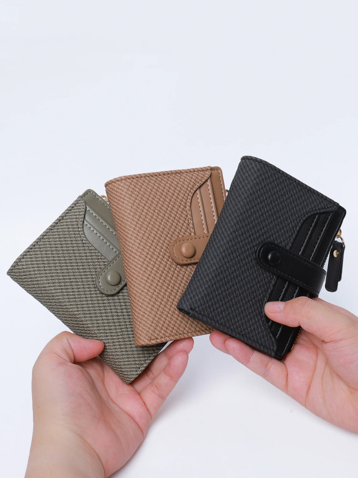A hand holds a premium PU leather bi-fold wallet in shades of olive green, beige, and black.