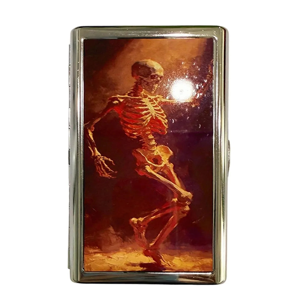 A vintage metal card holder featuring a depiction of a human skeleton on a dark, fiery background.