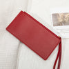 A red PU leather coin purse and card holder with a thin strap resting on a white textured fabric.
