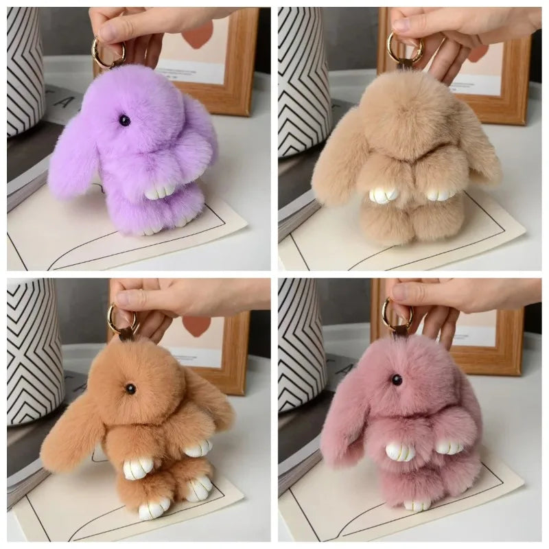 Four plush rabbit charms in purple, beige, brown, and pink colors displayed on white cards.