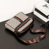 A brown leather crossbody sling bag with a patterned print and a matching strap is displayed on a dark surface.