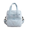 Bolsa reutilizable aislada de color azul claro con diseño acolchado y correas de transporte.