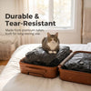 A cat sits on a brown storage box containing a black vacuum storage bag on a white bed.