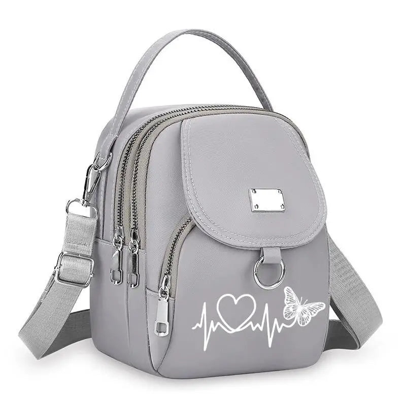 Sac bandoulière floral gris clair et durable avec fermeture éclair et sangle réglable.