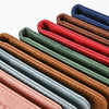 A row of genuine PU leather passport and ticket wallet covers in various shades of brown, green, blue, and red.