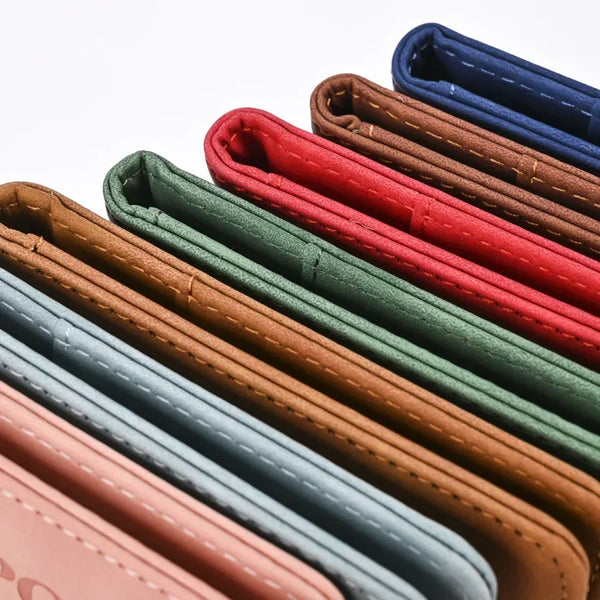 A row of genuine PU leather passport and ticket wallet covers in various shades of brown, green, blue, and red.