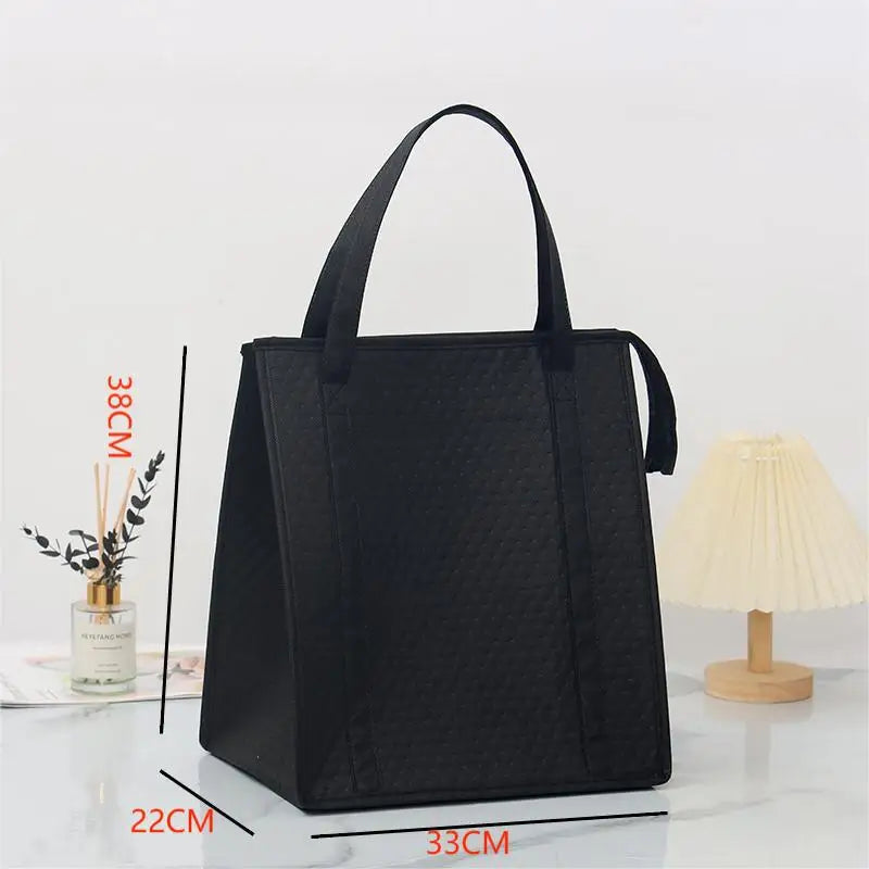 Black insulated tote bag shown with dimensions and a lamp in the background.