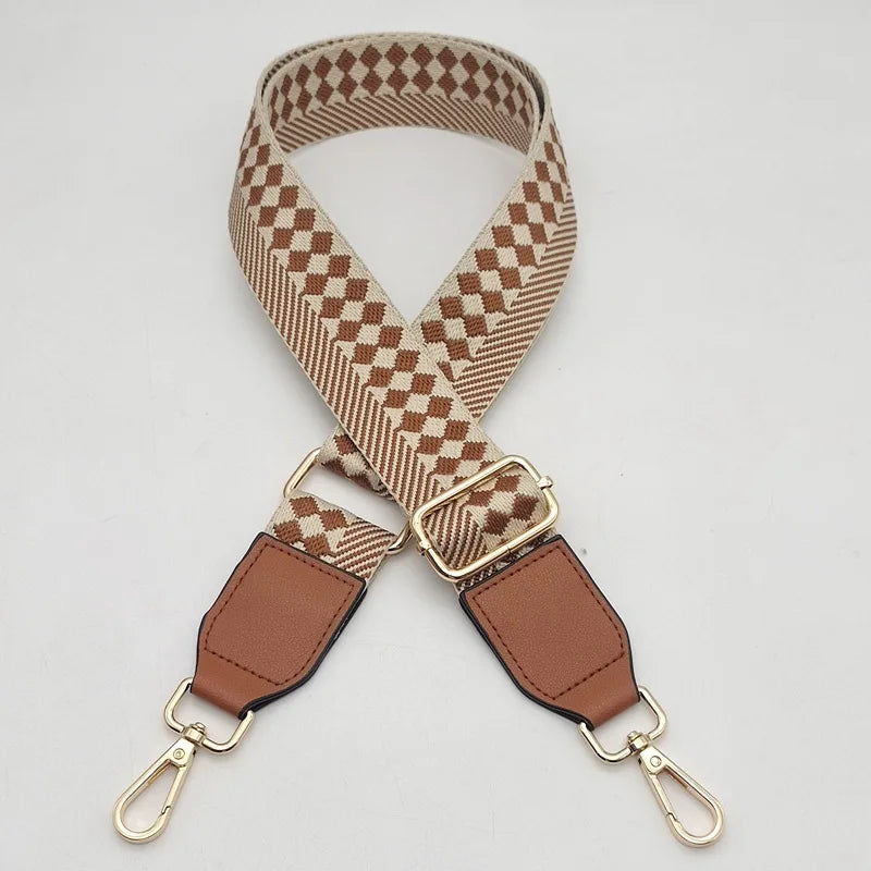 A beige and brown checkered braided nylon bag strap with metal hooks.
