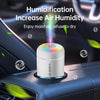A white humidifier device is placed on a car interior panel, emitting a mist of moist air.