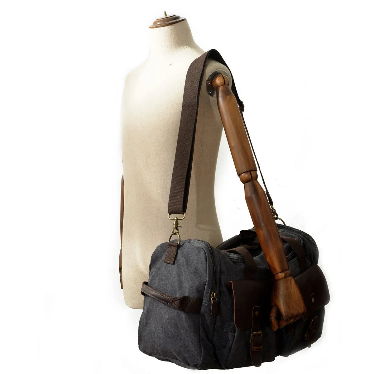 Eine braun-gestreifte Tasche aus dunkelgrauem Canvas mit braunen Lederakzenten und Holzgriff.