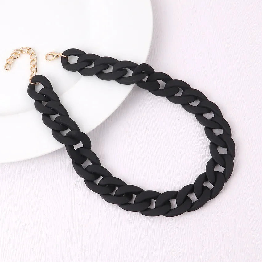 Black braided acrylic choker necklace with gold-tone clasp displayed on a white background.