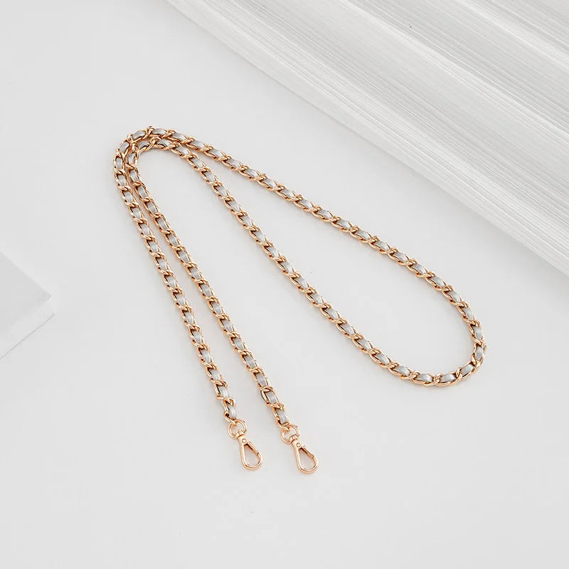 A delicate gold-toned chain strap with a small buckle is displayed on a white background.