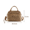 A tan floral corduroy insulated lunch bag with brown handles and a leopard print pattern.