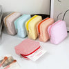 A collection of colorful striped storage pouches in pastel shades, including pink, yellow, and mint green.