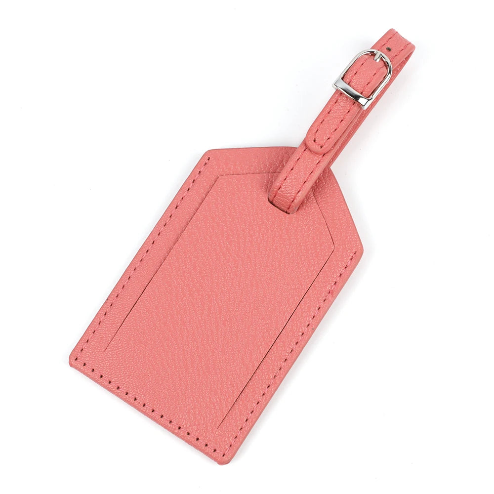 A pink PU leather luggage tag with a silver buckle attached to a strap.