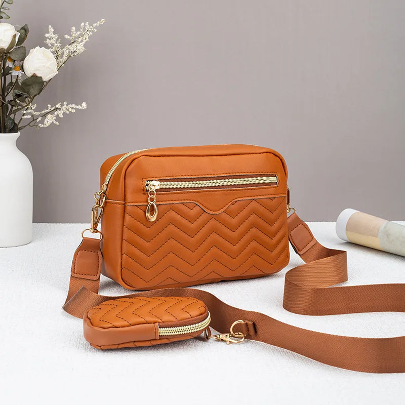 Tan gesteppte Crossbodytasche mit goldfarbener Kette und Lederriemen auf weißem Untergrund