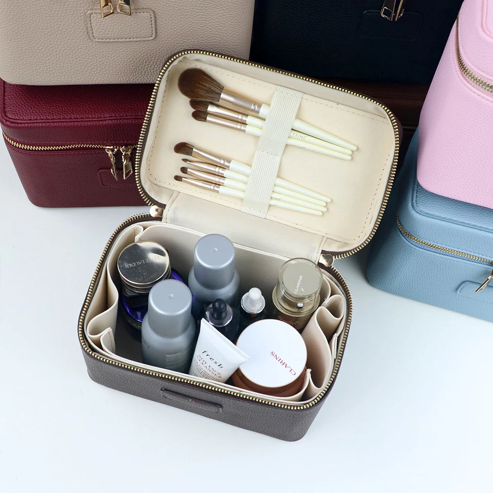 A gray makeup bag with compartments holds various cosmetic tools and products like brushes and jars.