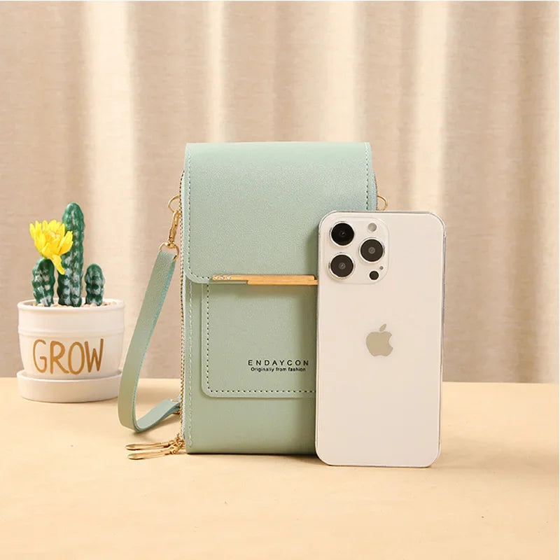 A light mint green luxury women's crossbody shoulder bag next to an iPhone 12 Pro Max.