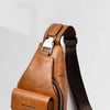 A brown men's PU leather belt sling chest bag with a dark brown strap shown in a studio setting.