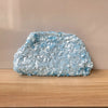 A light blue beaded chain shoulder clutch bag resting on a wooden surface.