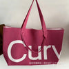 A pink knitted large tote bag with a white logo featuring the word curvy