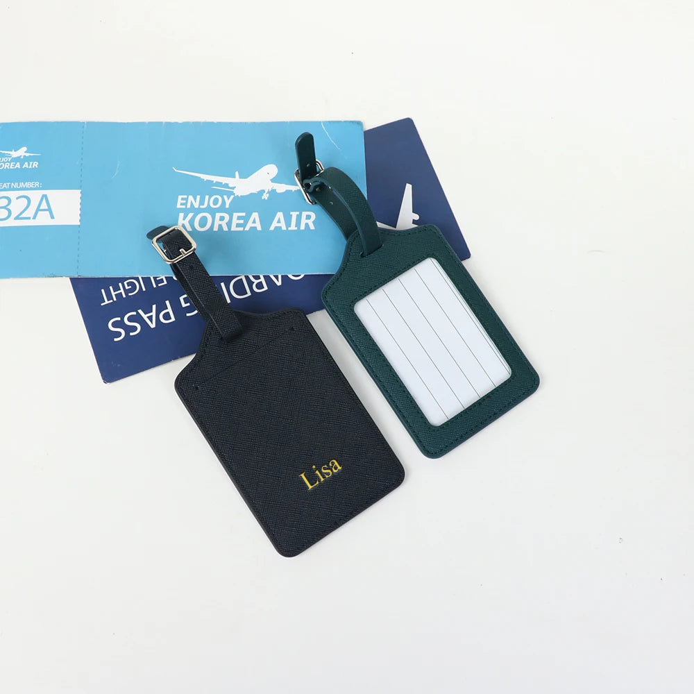 A set of two custom PU leather luggage tags featuring a cross-pattern detail and personalized names