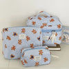 A set of striped bear cosmetic makeup bags in light blue and white fabric.