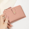 A hand holds a pink PU leather card holder wallet with a stitched flap and gold accent.