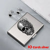 Silver card holder with a skull design and ten cards displayed on a gray surface.