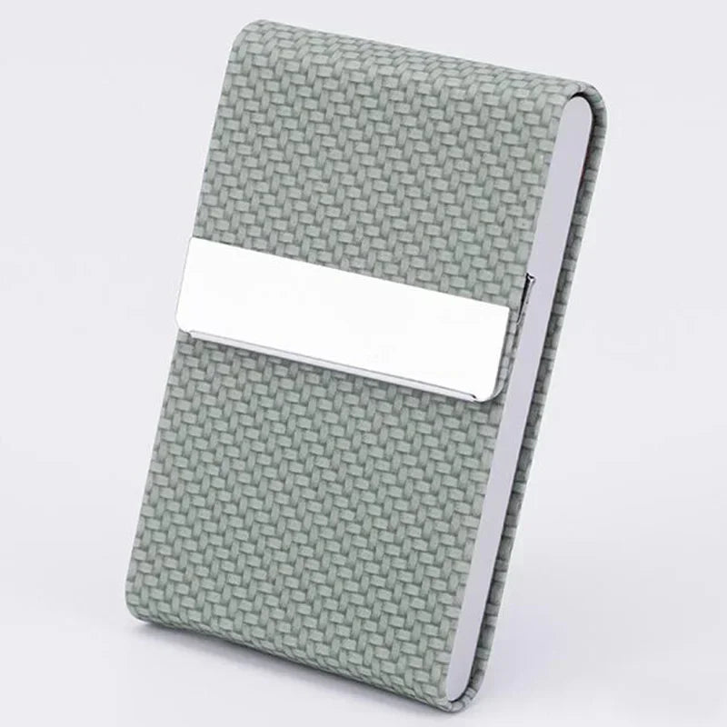 A light sage green business card holder with a white rectangular slot on the front.