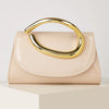 A pale pink elegant women's clutch purse with a gold-toned handle resting on a light surface.