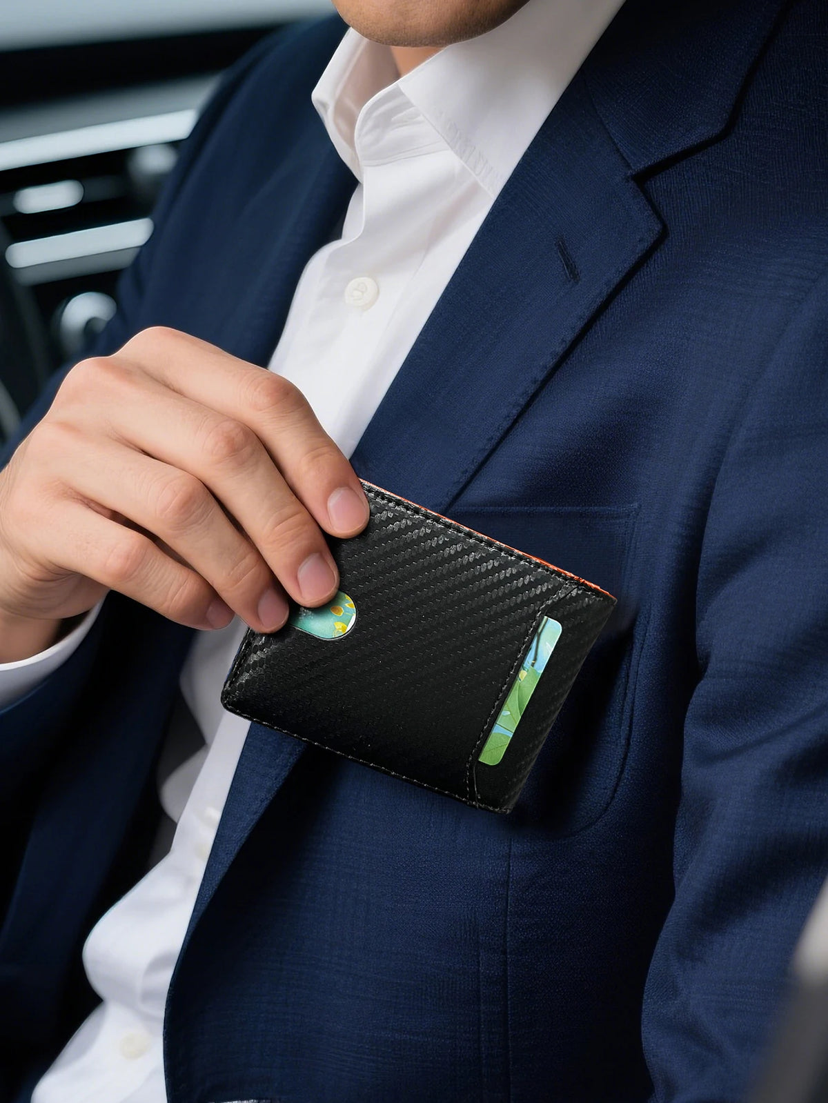A hand in a navy suit jacket is holding a black carbon fiber wallet with an ID window.