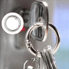 Close-up view of a sturdy metal key ring clip with a spring-loaded fastener and attached keyring.