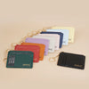 A collection of pastel-colored ultra-thin card holder wallets with gold keychains arranged on a light background.
