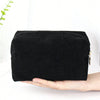 Black corduroy makeup organizer bag with an octagonal design held in a hand.