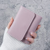 A hand holds a light pink slim multi-functional card wallet for students.