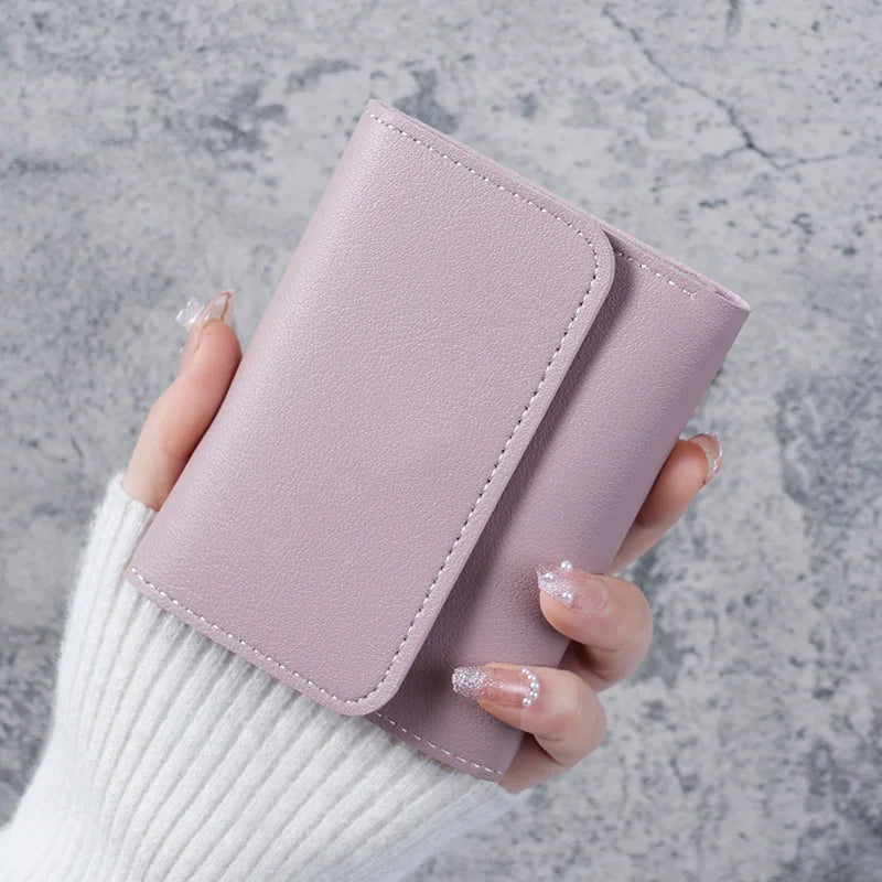 A hand holds a light pink slim multi-functional card wallet for students.