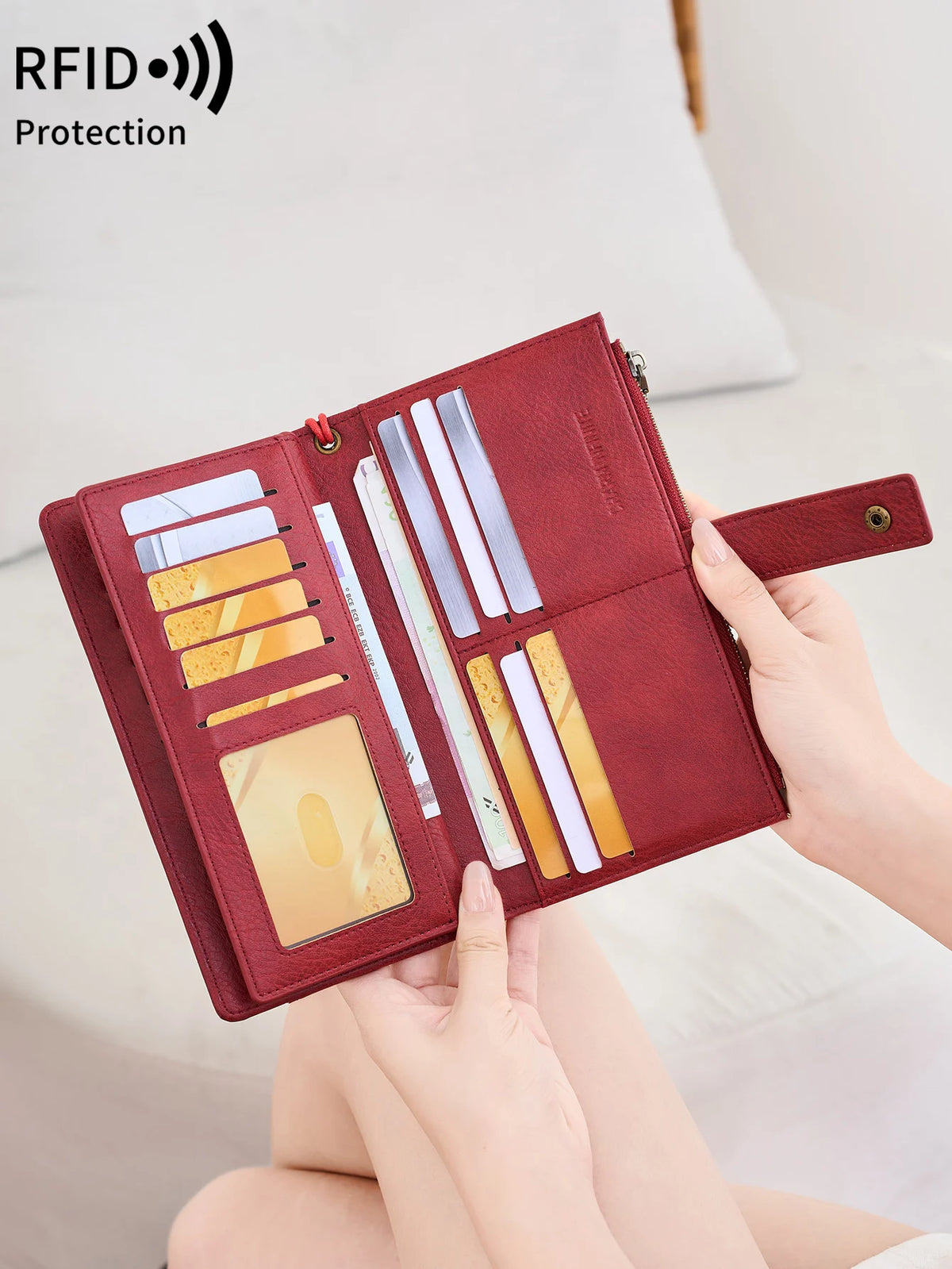 Primer plano de una billetera de cuero granate con varias tarjetas y funciones de protección RFID, sostenida por una persona.