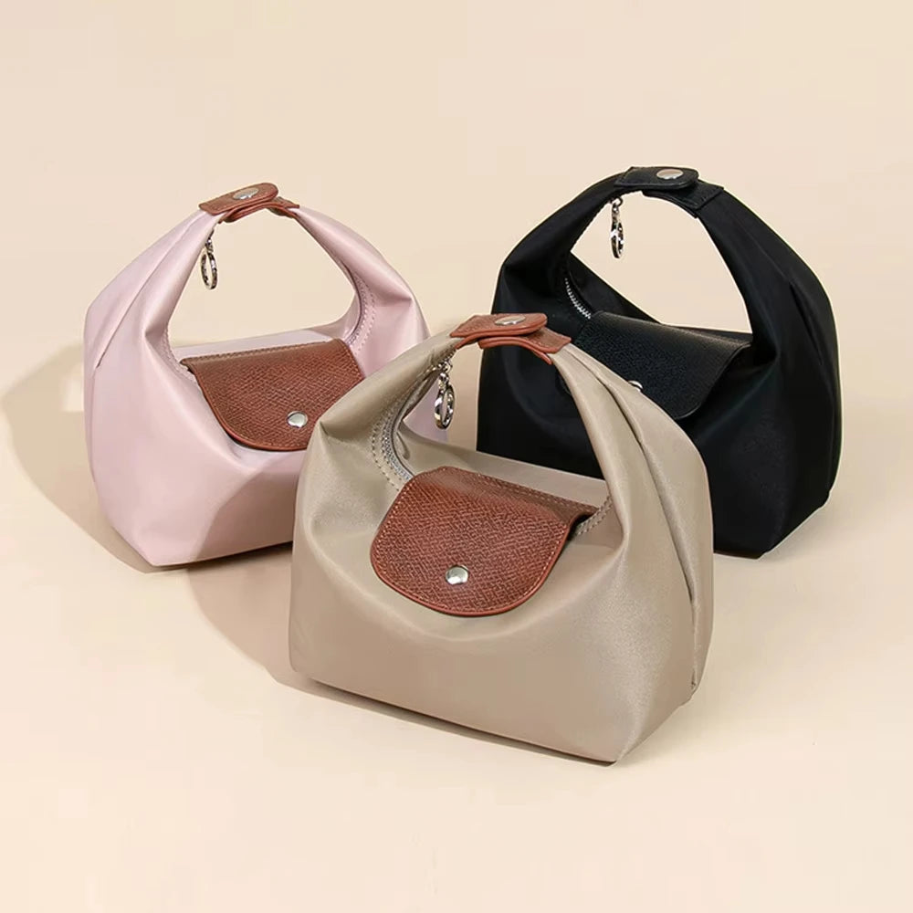 A set of two waterproof nylon crossbody bags in pink and black with brown leather accents.
