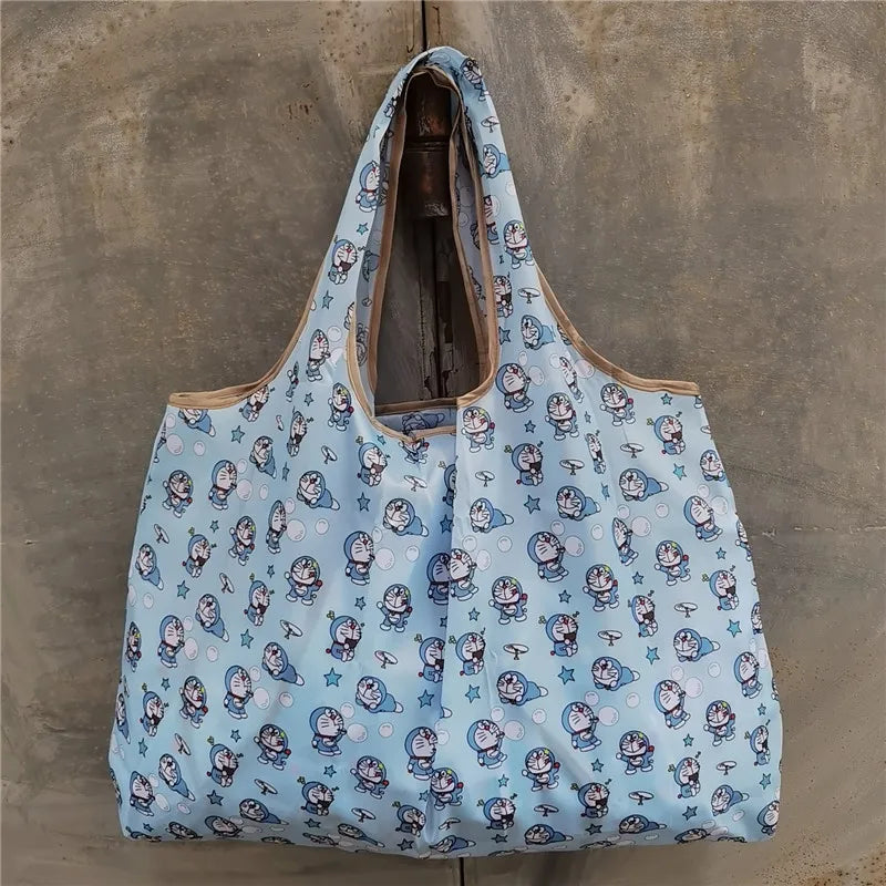 A light blue patterned reusable shopping bag hanging against a gray concrete wall.